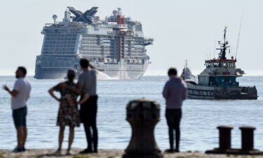 Pedestrians look at the Royal Caribbean (RCCL) cruise ship Celebrity Beyond as it leaves Les chantiers de l'Atlantique shipyards