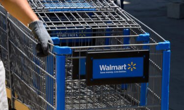 An employee gathers shopping carts at a Walmart in Burbank