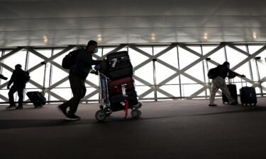 Travelers walk with their luggage at San Francisco International Airport on July 01