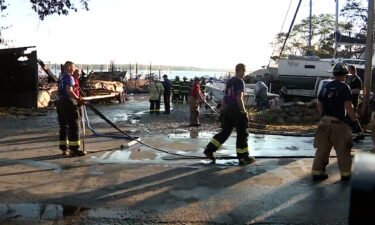 Firefighters work at the scene of a massive boatyard fire in Mattapoisett