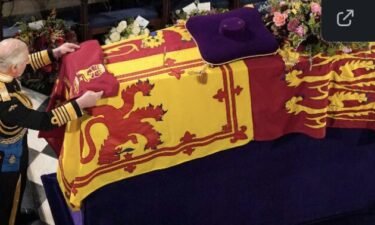King Charles III places the Queen's Company Camp Colour of the Grenadier Guards on his mother's coffin during the committal service that was held at St. George's Chapel in Windsor Castle on September 19.