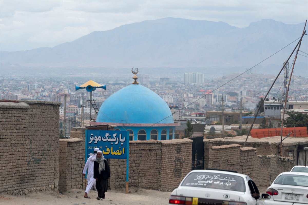 <i>AFP via Getty Images</i><br/>The Biden administration has set up a new fund that could eventually put billions of dollars in frozen Afghan money to use to promote economic stability. Afghan men are pictured here walking past the blue dome of a mosque a day after a blast in Kabul.