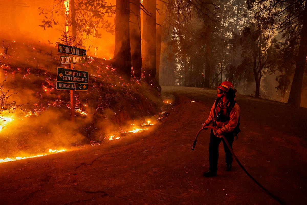 <i>Fred Greaves/Reuters</i><br/>A firefighter monitors flames from the Mosquito Fire in Placer County