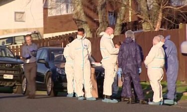 Police and forensic investigators gather at the scene where suitcases with the remains of two children were found in Auckland
