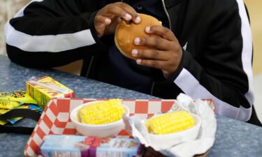A student eats a cheeseburger during lunch at a school in Georgia. Food insecurity among families with children fell in 2021