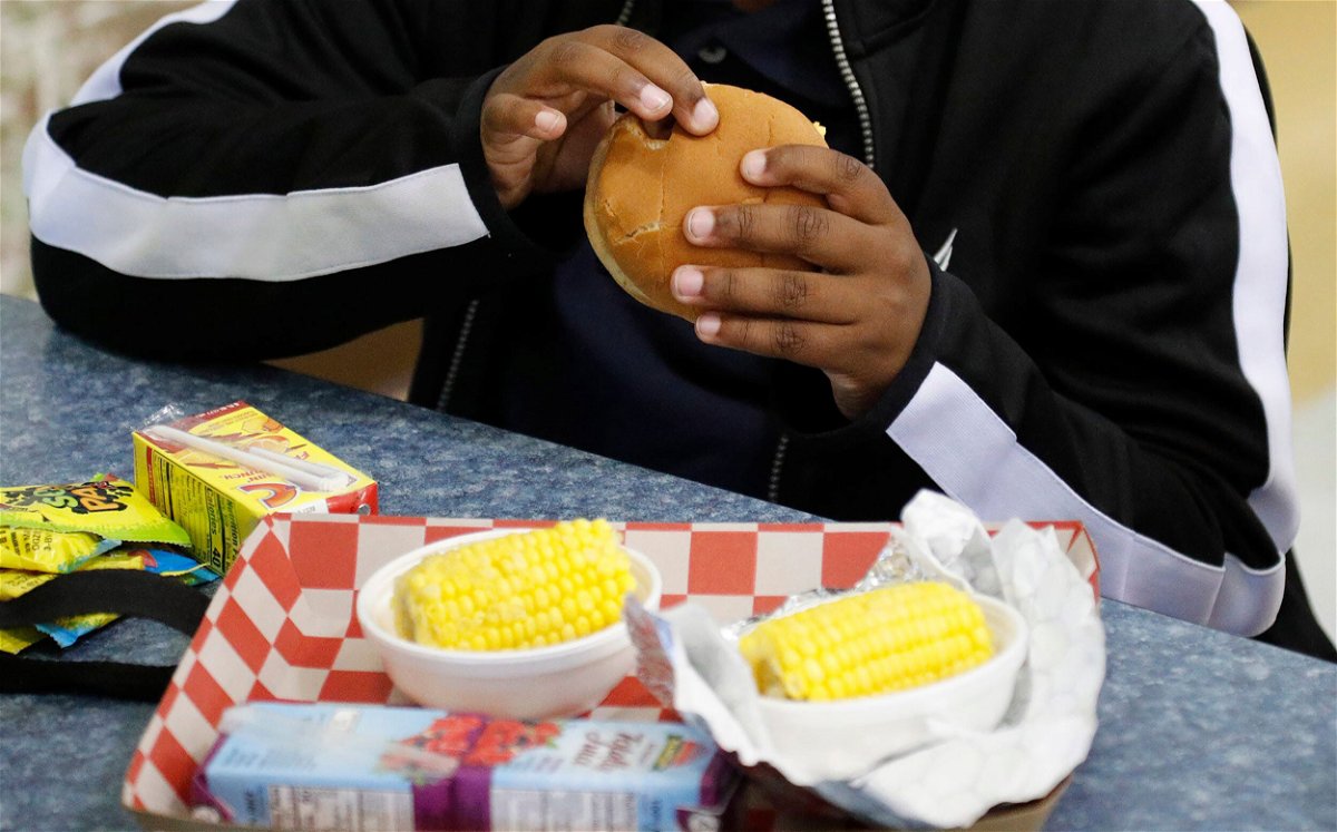 <i>Richard Burkhart/Savannah Morning News/USA Today Network</i><br/>A student eats a cheeseburger during lunch at a school in Georgia. Food insecurity among families with children fell in 2021