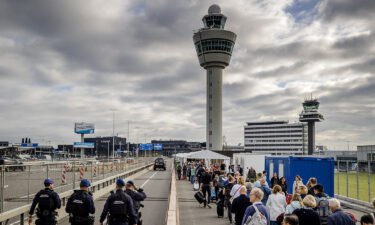 Travelers queue outside Schiphol airport