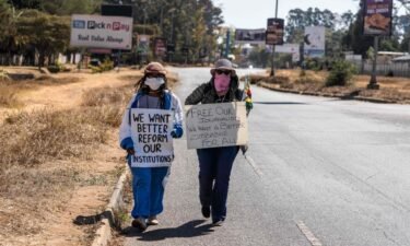 Zimbabwean novelist Tsitsi Dangarembga (left) and colleague Julie Barnes hold placards during an anti-corruption protest march in July of 2020 in Harare.