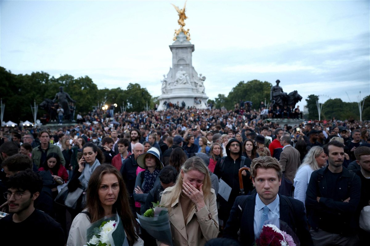 <i>Henry Nicholls/Reuters</i><br/>People react outside the Buckingham Palace after the announcement of the death of the Queen.