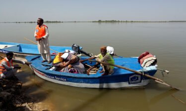 Flood victims are seen here receiving relief aid in Sindh province's Sukkur city on the Indus River on September 4. Authorities in Pakistan have warned it could take up to six months for deadly flood waters to recede in the country's hardest-hit areas.