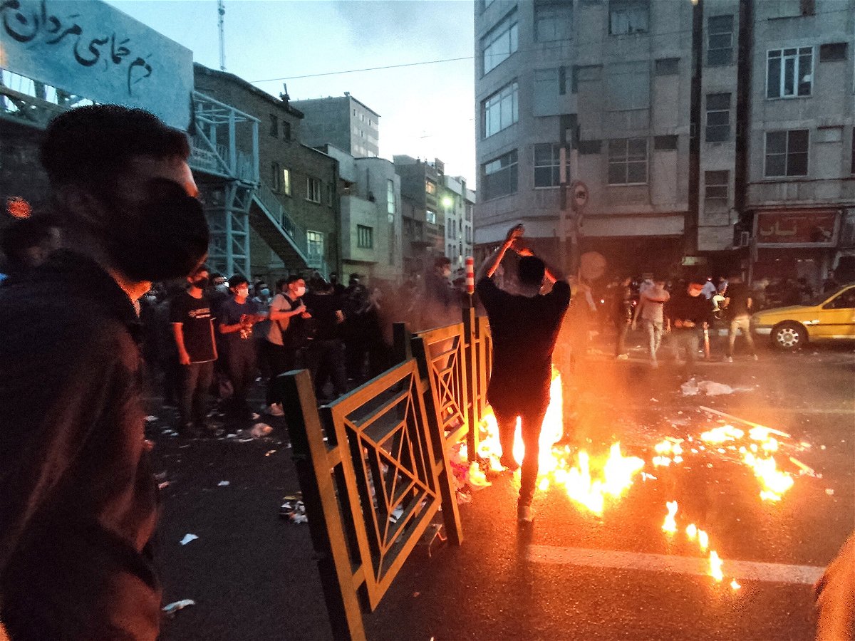 <i>West Asia News Agency/Reuters</i><br/>People light a fire during a protest over the death of Mahsa Amini in Tehran on September 21.