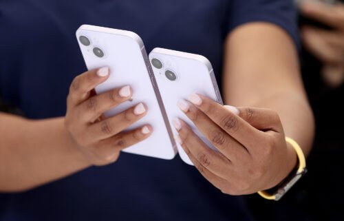Shares of Apple fell 4% in early trading September 28 amid concerns about demand for the company's latest lineup of iPhones. An Apple employee is seen here holding a new iPhone 14 and iPhone 14 Plus during an Apple special event on September 07.