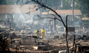 Firefighters survey homes destroyed by the Mill Fire in Weed