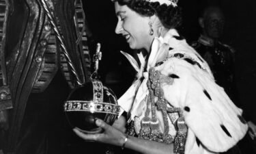 Queen Elizabeth II wearing the Imperial State Crown and carrying the Orb and scepter after her coronation.