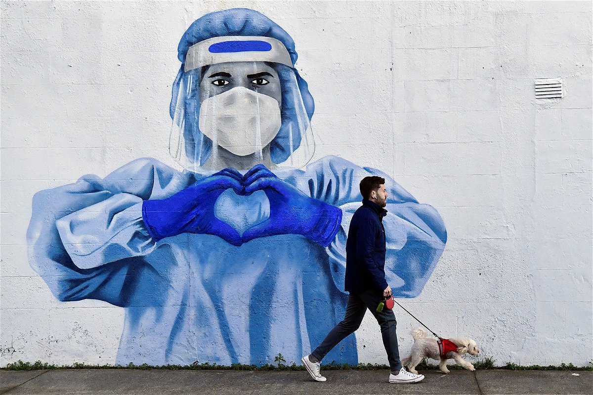 A man walks his dog past a mural depicting a frontline worker amid the spread of Covid-19 in Dublin, Ireland, on January 12. President Joe Biden lit a firestorm of controversy this week when he said in an interview that 