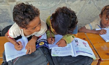 Yemeni children attend class outdoors in a heavily-damaged school on the first day of the new academic year in Yemen's war-torn western province of Hodeida.
