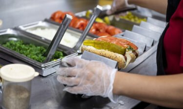 An employee prepares a hot dog at a Portillo's restaurant in Chicago