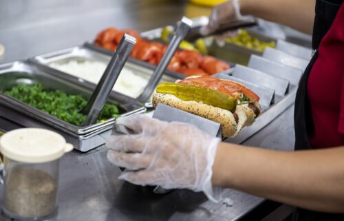 An employee prepares a hot dog at a Portillo's restaurant in Chicago