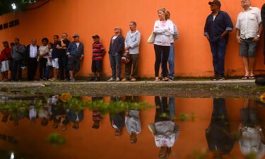 People queue to vote just outside Rocinha favela in Rio de Janeiro.