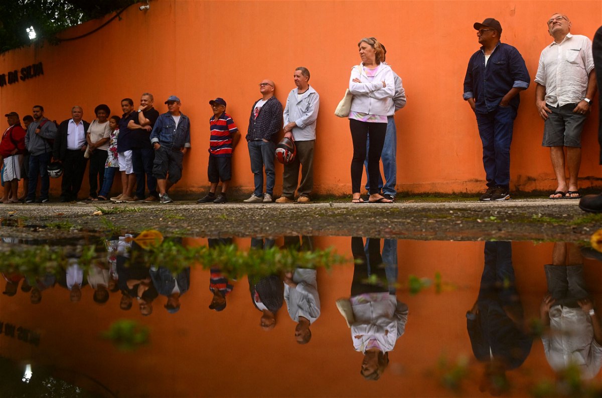 <i>Andre Borges/AFP/Getty Images</i><br/>People queue to vote just outside Rocinha favela in Rio de Janeiro.