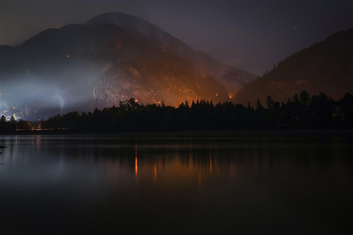 <i>Darryl Dyck/The Canadian Press/AP</i><br/>The Flood Falls Trail wildfire burns above the Fraser River in Hope