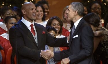 Dwayne "The Rock" Johnson and former US President Barack Obama shake hands during a taping of the Christmas in Washington concert at the National Building Museum December 14