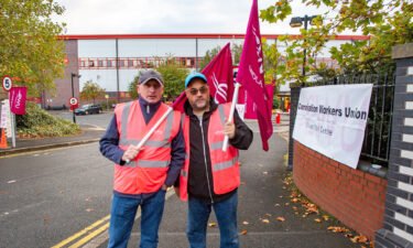Royal Mail workers are seen on strike at the main entrance of Wolverhampton Royal Mail Center on October 13.