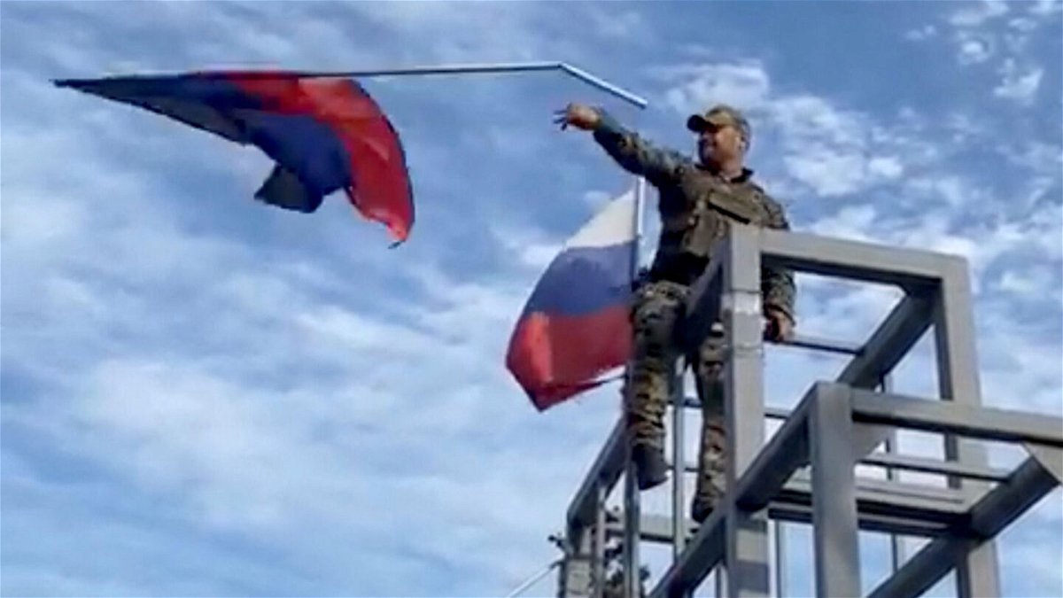 <i>Oleksiy Biloshytskyi/Reuters</i><br/>A member of the Ukrainian troop brings down a Donetsk Republic flag hoisted on a monument in Lyman