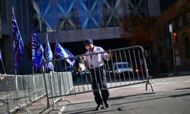 A security guard sets up a barricade in front of a designated demonstration area for supporters of President Donald Trump outside of where votes were still being counted
