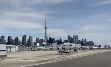 Airplanes sit on the tarmac at Billy Bishop Toronto City Airport in front of the CN Tower on July 4