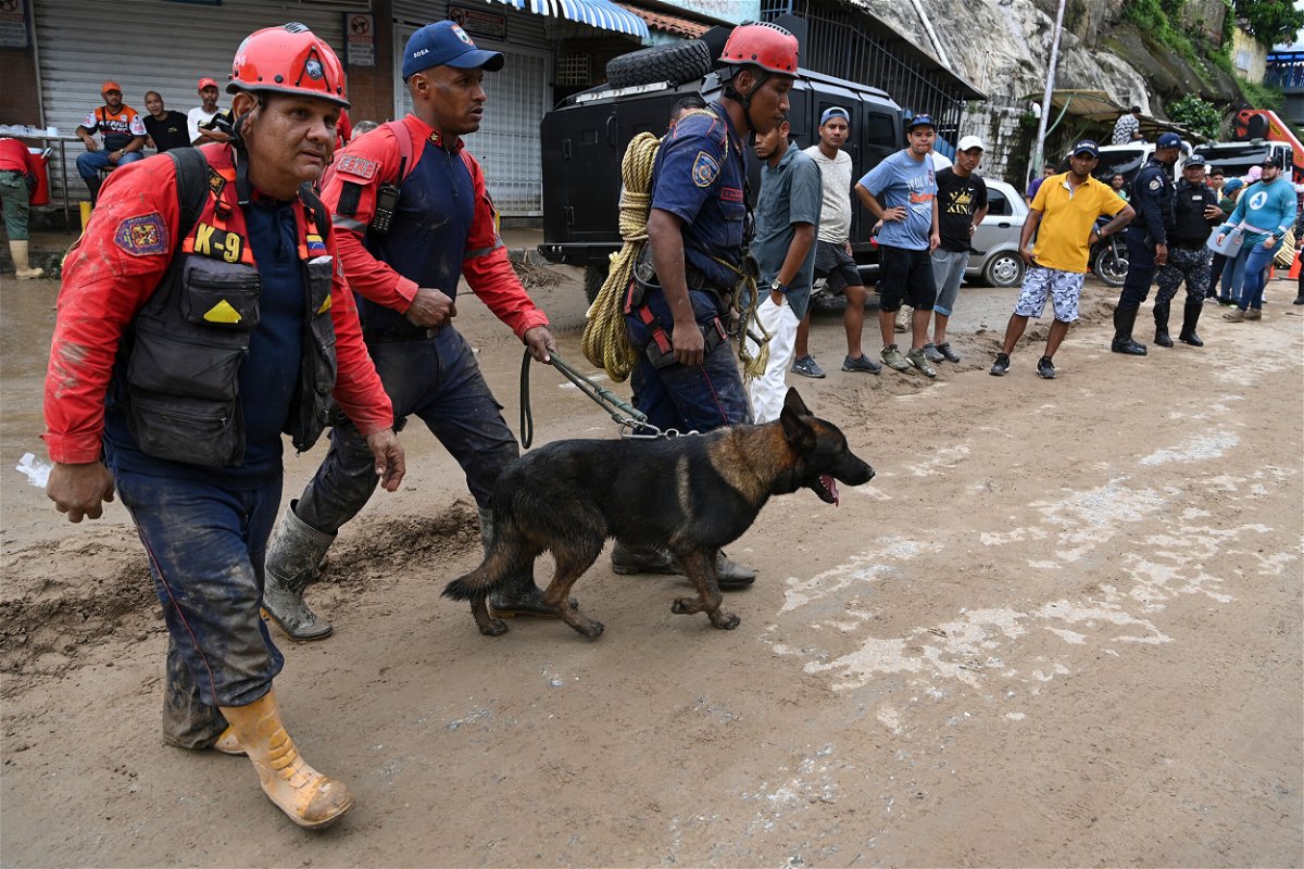 <i>Yuri Cortez/AFP/Getty Images</i><br/>Rescuers look for survivors of the landslide in Las Tejerias