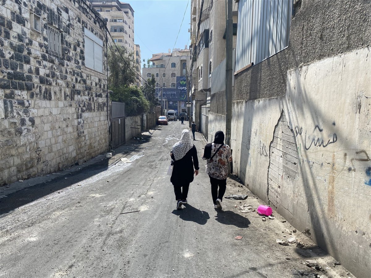 <i>Abeer Salman/CNN</i><br/>Two women walk along the narrow alleyways of the Shuafat refugee camp