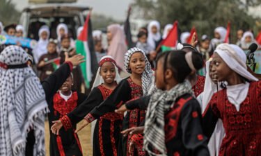 Palestinian girls wearing traditional embroidered dresses perform during a ceremony marking the start of the olive harvest season in Deir al-Balah in central Gaza on Sunday.