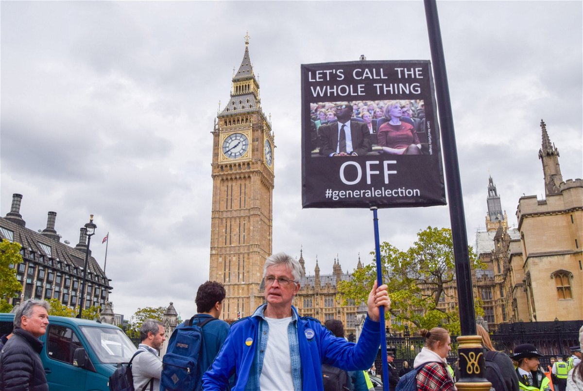 <i>Vuk Valcic/SOPA Images/LightRocket/Getty Images</i><br/>A protester holds a placard calling for a general election during the demonstration in Parliament Square in London