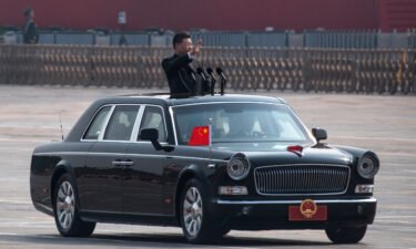Chinese President Xi Jinping waves as he drives after inspecting the troops during a parade to celebrate the 70th Anniversary of the founding of the People's Republic of China at Tiananmen Square in 1949