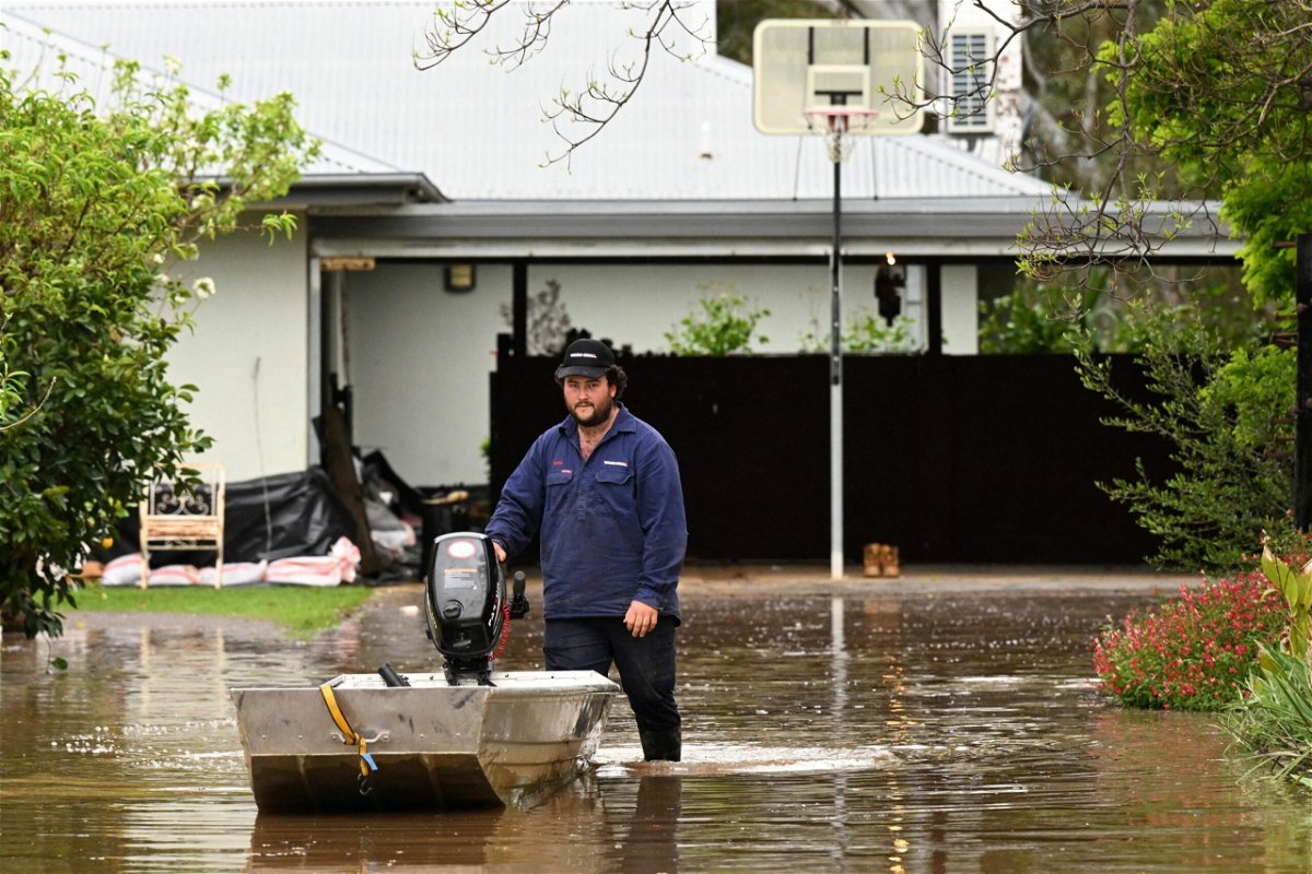 <i>Stringer/Reuters</i><br/>A man pushes a boat as floodwaters inundate a Victorian residential area in Rochester