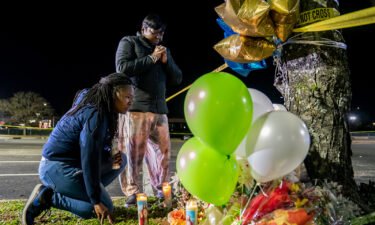 Lashana Hicks (left) joins other mourners Wednesday at a memorial for those killed in a mass shooting at a Walmart Supercenter in Chesapeake