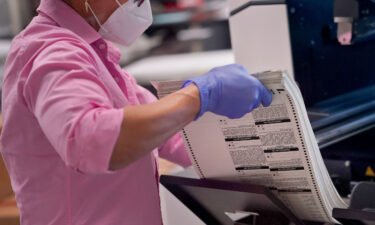 An election worker removes tabulated ballots from the machine inside the Maricopa County Recorders Office on November 10 in Phoenix.