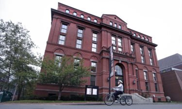 A cyclist rolls past the Peabody Museum of Archaeology & Ethnology at Harvard University in Cambridge