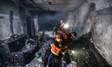 Palestinian firefighters extinguish flames in an building ravaged by fire in the Jabalia refugee camp in Gaza on November 17. At least 21 people