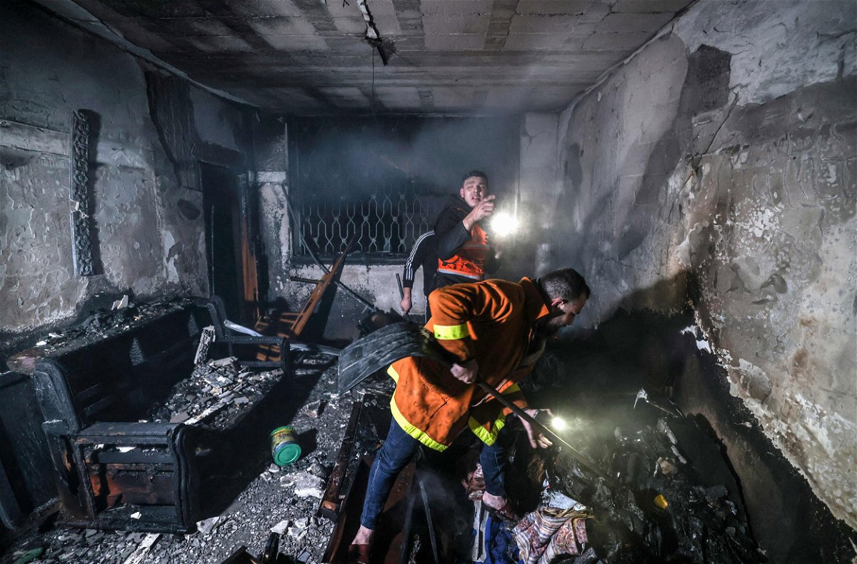 <i>Mahmud Hams/AFP/Getty Images</i><br/>Palestinian firefighters extinguish flames in an building ravaged by fire in the Jabalia refugee camp in Gaza on November 17. At least 21 people