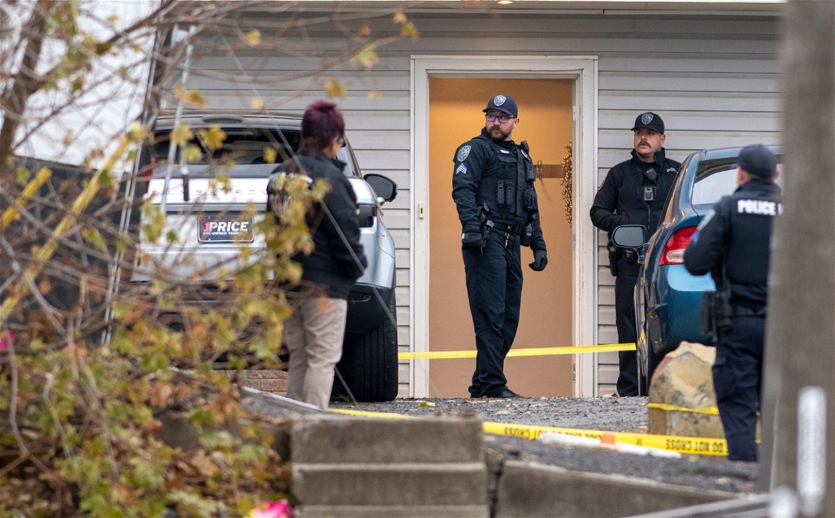 Idaho police ask for calm after quadruple homicide. Officers investigate Sunday at the crime scene.