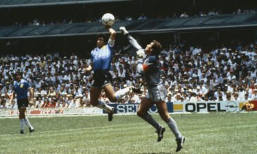 Diego Maradona of Argentina handles the ball past Peter Shilton of England to score the opening goal of the World Cup Quarter Final at the Azteca Stadium in Mexico City