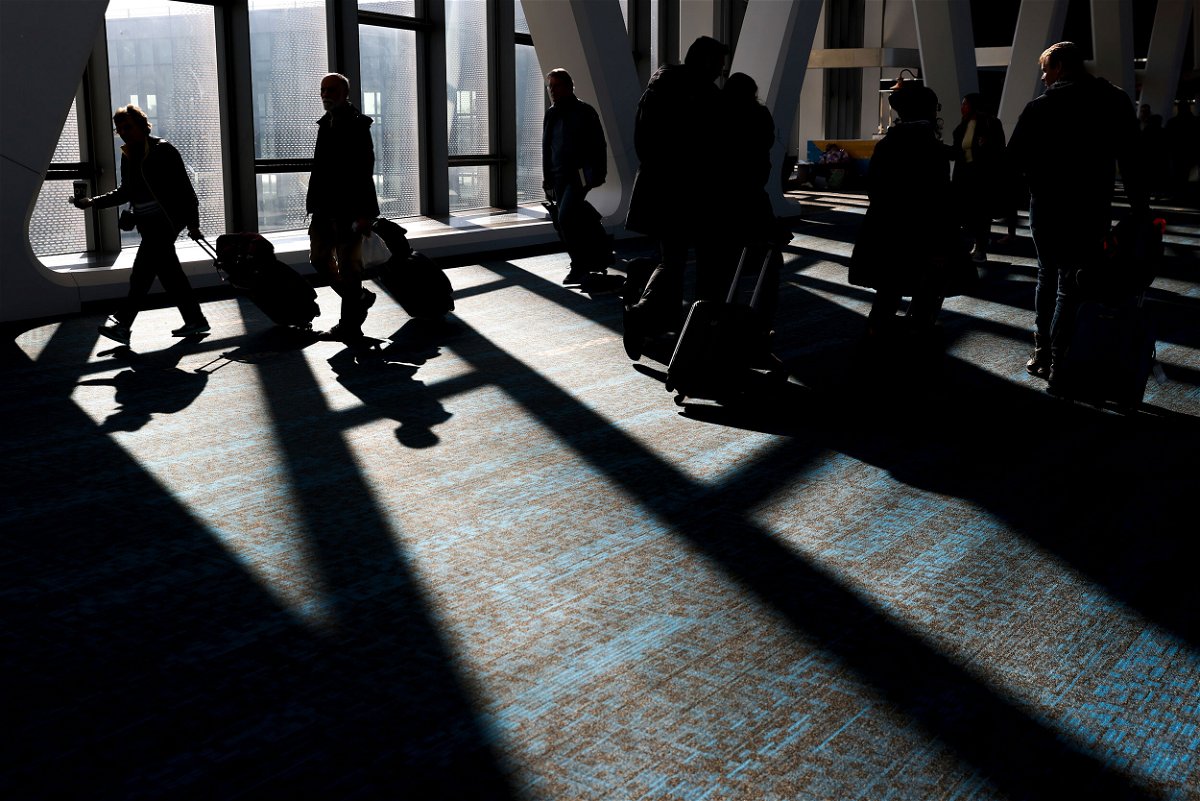 <i>Julia Nikhinson/AP</i><br/>Travelers walk through LaGuardia Airport in New York on November 22. Travel experts say the ability of many people to work remotely is letting them take off early for Thanksgiving or return home later.
