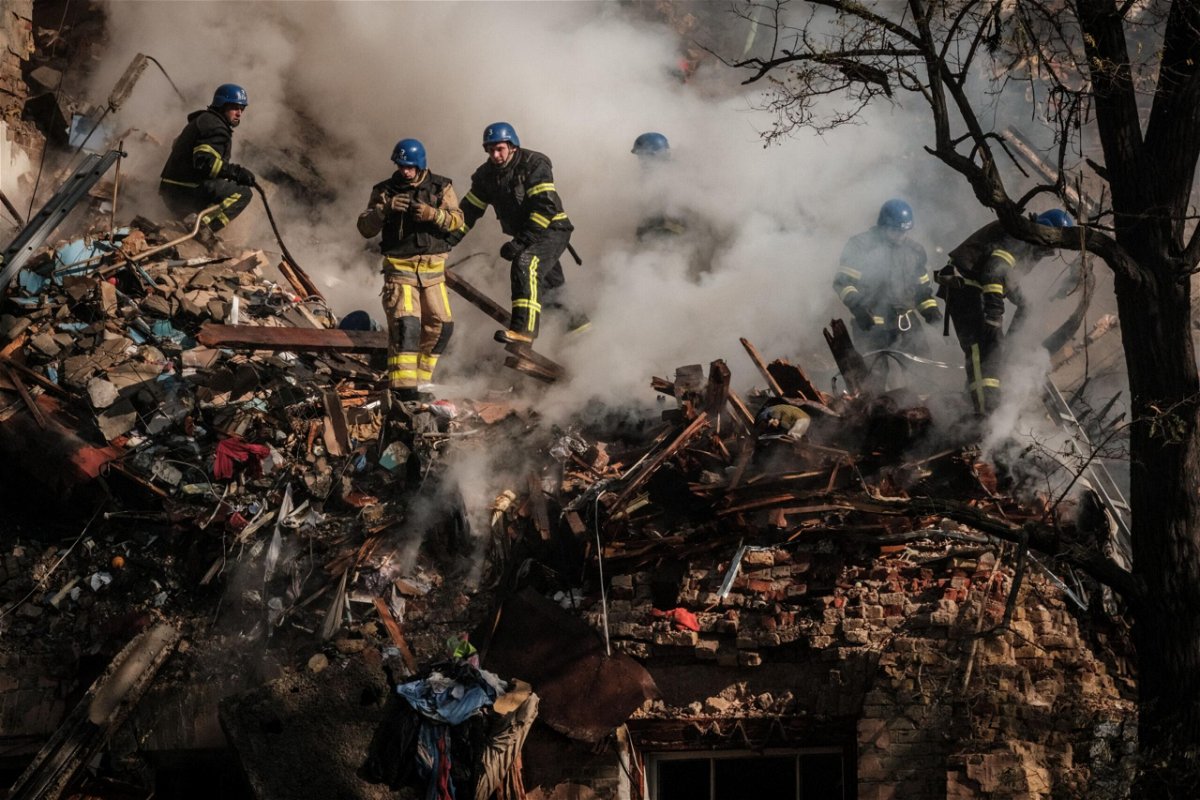 <i>Yasuyoshi Chiba/AFP/Getty Images</i><br/>Ukrainian firefighters work on a destroyed building after a drone attack in Kyiv on October 17.