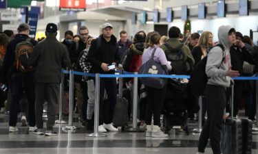 Sunday marked the busiest day at US airports since the start of the pandemic. Travelers wait to go through security check point at O'Hare International Airport in Chicago