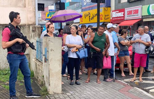 Local residents gather outside the police station where the alleged perpetrator of two school shootings is being held in Aracruz.
