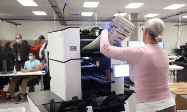 An election worker inserts a stack of ballots into a scanning machine at the Maricopa County Tabulation and Election Center on November 10 in Phoenix