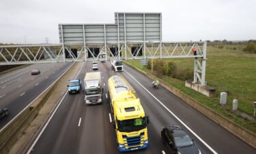 Activists from Just Stop Oil are pictured here climbing a gantry on the M25 highway near London Colney in Hertfordshire.