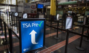 The price for TSA PreCheck has dropped. A sign directs travelers enrolled in the TSA pre-check system to a short security line at Reagan National Airport in Arlington